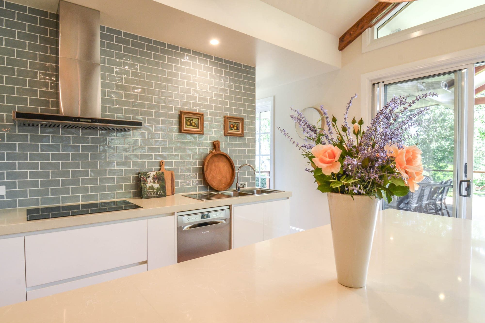 Kitchen island bench detail with quartz stone top and rattan bar stools