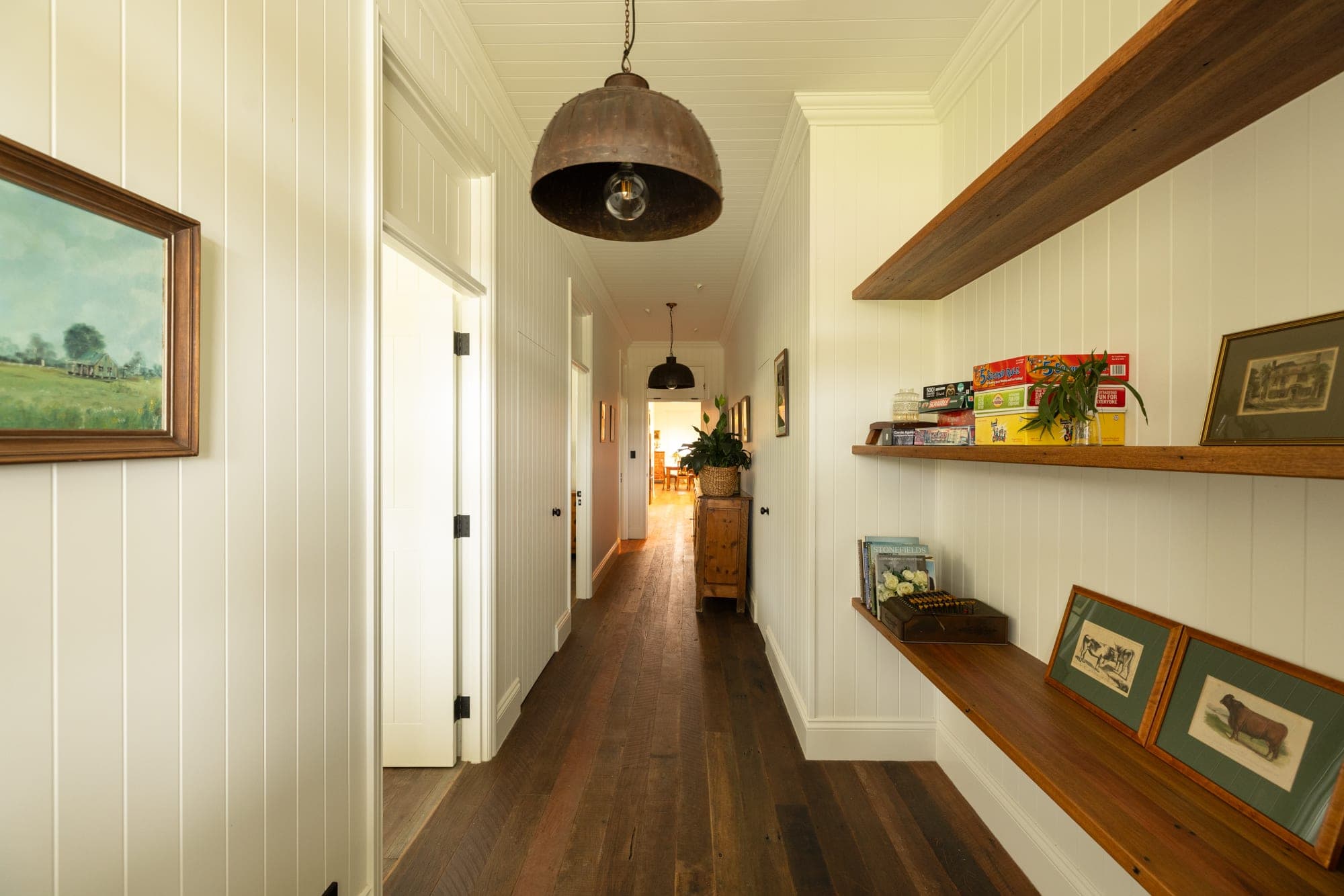 Hallway with dark hardwood timber floors, pendant barn lights and reclaimed timber floating shelves